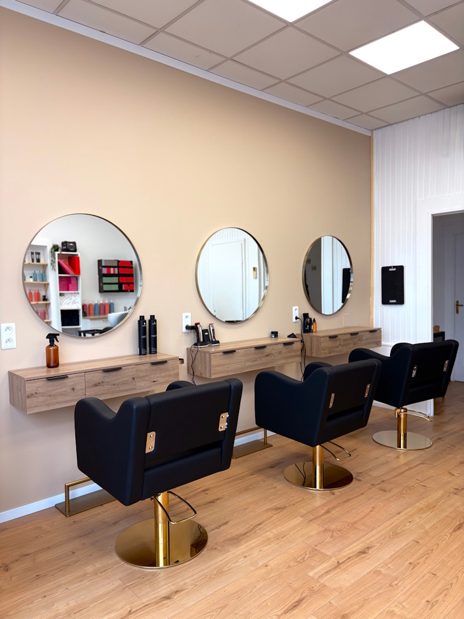 Salon de coiffure moderne avec trois fauteuils noirs